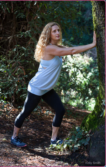 Mary Hohlman stretching against sequoia tree